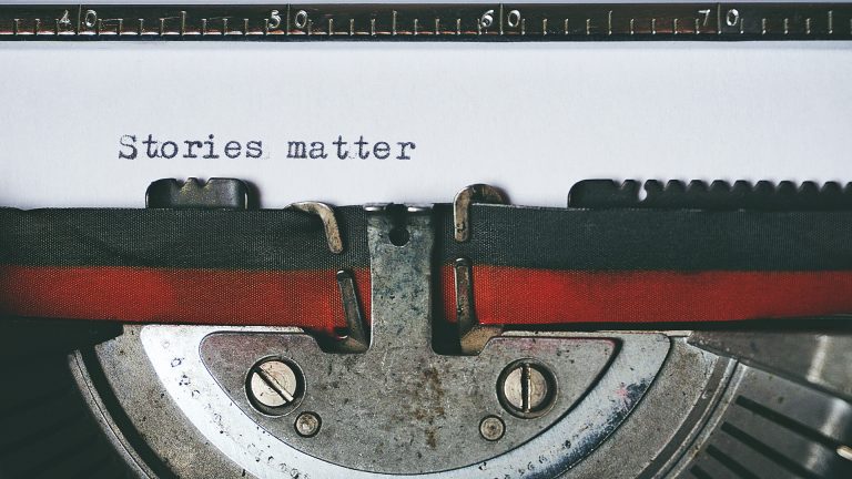 Klassische Schreibmaschine mit den Wörtern Stories matter auf Papier