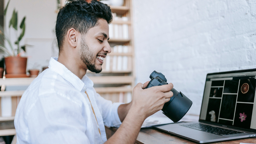 A smiling man looking at the content produced at the trade fair stand on his camera.